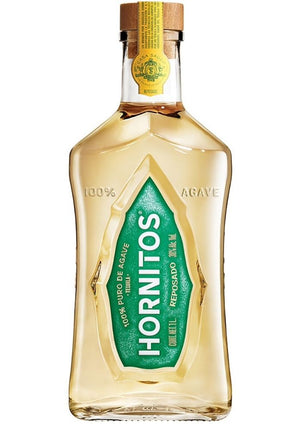 Vista de una botella de cristal con tapón de madera y una etiqueta verde que dice “Hornitos Reposado 1Lt. 100% puro de Agave”. Se aprecia su contenido del tequila mexicano color amarillo claro. 